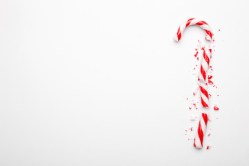 Broken Christmas candy cane on white background. Minimal composition with peppermint candy. Top view