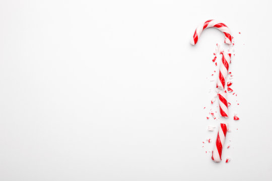 Broken Christmas Candy Cane On White Background. Minimal Composition With Peppermint Candy. Top View