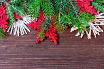 Christmas and New Year theme decorated background, top view, with Christmas tree branches, ornaments on dark wooden background