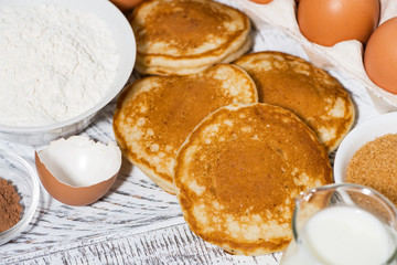 ingredients for baking pancakes on white wooden table, closeup
