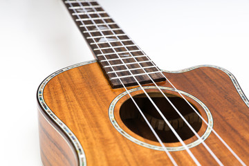 Obraz premium Ukulele on a white background. Hawaiian guitar lies on the table.