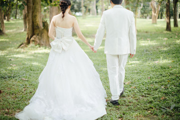 Newlywed couple walking holding hands in garden,valentine day concept. 