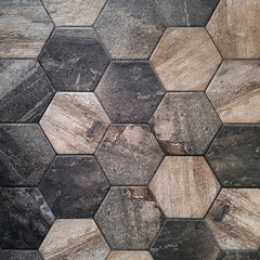 The texture of the ceramic tiles in the form of a hexagon made of brown natural stone. Concept texture, background
