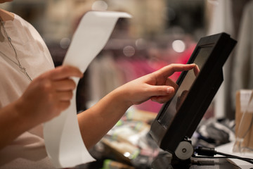 Naklejka premium Young woman hands scaning / entering discount / sale on a receipt, touchscreen cash register, market / shop, finance concept, business