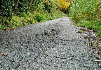 Una strada dissestata a causa di uno smottamento del terreno. 