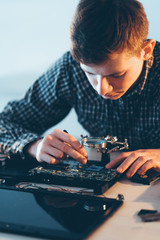 Electronic engineering. Computer maintenance. Male technician installing cpu to laptop motherboard.