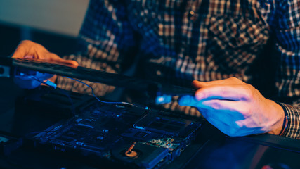 Engineering hobby. Hardware development. Disassembled laptop components in technician hands.