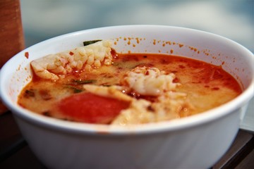 Tom Yam soup in a white plate on the table