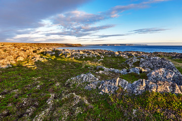 The rocky landscape as viewed from Hamningberg fort area in Varanger Peninsula of Norwegian Finnmark. Lands of Ytre Sylvetica natural reserve and waters of Barents Sea are at background.