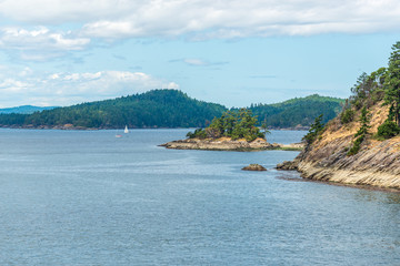 View over inlet, ocean and island with boat and mountains in beautiful British Columbia. Canada.