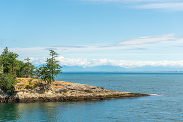 View over inlet, ocean and island with boat and mountains in beautiful British Columbia. Canada.
