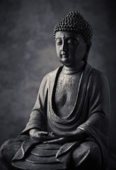 Meditating Buddha Statue on dark background. Copy space. 