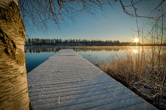 Snowy bridge in the lake sunrise scenery
