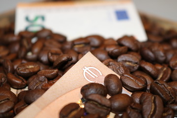 Texture of roasted coffee beans and 50 Euro bills. Side view.