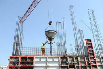 A worker controls concrete bucket used in pouring concrete at construction site