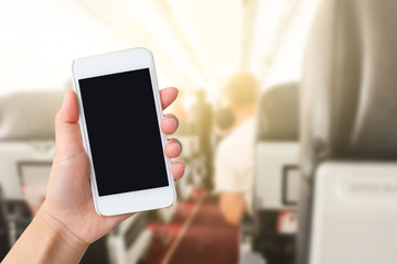 Smart phone with white screen in hand on blurred in airport background