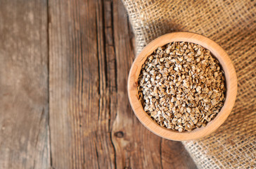 Tomato seeds in a wooden plate on the sackcloth, copy space