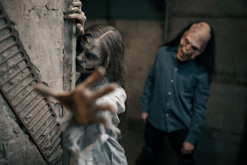 Fototapeta na wymiar Zombie couple in abandoned factory, devil family
