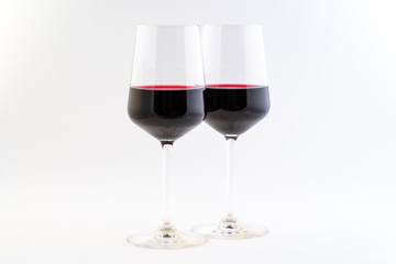 Two clean shiny wine glasses with red wine