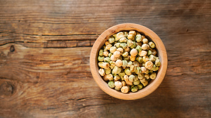 Pea seeds in a wooden plate, copy space