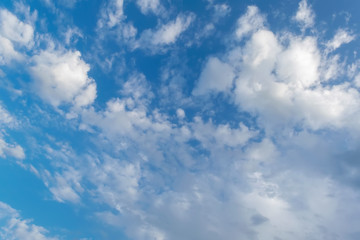 Blue summer sky with bright white cumulus clouds.