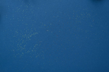Bright blue background with sequins on it. Copy space