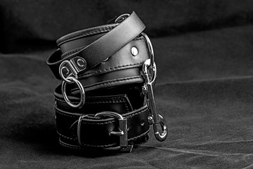 Pair of a black color fetish leather handcuffs.