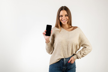Naklejka premium cheerful woman showing empty blank screen on phone in hand isolated over white