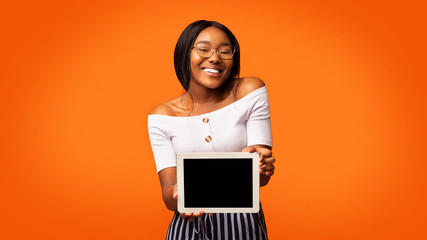Afro Girl Showing Digital Tablet Screen Standing In Studio, Panorama