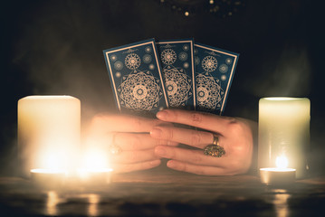 Fortune teller with tarot cards in hands close up. Future reading concept.