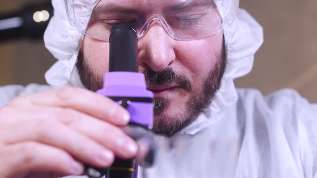 Scientist looking into a microscope in chemical medical biology biotechnology pharmacology laboratory. Bio lab research. Science about DNA. Chemistry development. Ecology biological experiment.
