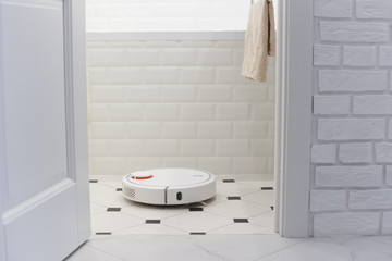 White robot vacuum cleaner in bathroom