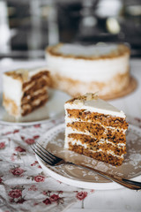 beautiful Healthy Homemade Carrot Cake on plate on the background of a blurred whole cake on a stand