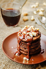 chocolate pancake with bananas, nuts, chocolate sauce and glass of coffee