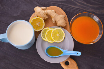 Jam with sea buckthorn juice with ginger and lemon on a wooden background. Conceptual autumn vitamin drink to enhance health and immunity.