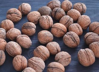 Ripe apples and walnuts on the table. Peeled nuts and shelving from them.