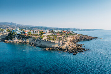 Aerial view of beautiful nature cliff with villas or houses near Coral Bay beach in Paphos, Cyprus. Drone photo of mediterranean seascape background.