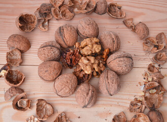 Ripe apples and walnuts on the table. Peeled nuts and shelving from them.