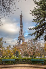 Paris, France - November 24, 2019: Green bench in Autumn with the Eiffel Tower in the background in Paris France