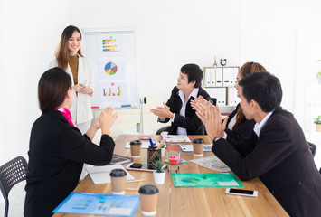asian female officer present about organization business profits with executive board, audience clapping hands and feeling impressive, they discussion about performance and success development result