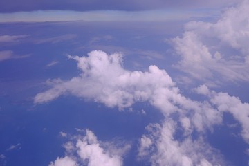 Obraz premium White fluffy clouds against blue sky in bright day ,a view from plane window