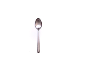 A small stainless glossy spoon on white isolated background with copy space 