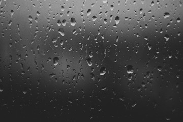 blue rain drops on glass background black and white