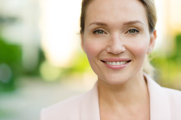 Close-up portrait of a smiling woman on the street. Happy woman's face closeup, outdoors. Happy...