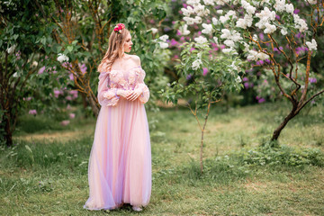 Obraz na płótnie Canvas Beautiful romantic fairy girl in long dress in blooming spring garden. Gorgeous young model with perfect hairstyle in fairy forest. Fantasy art