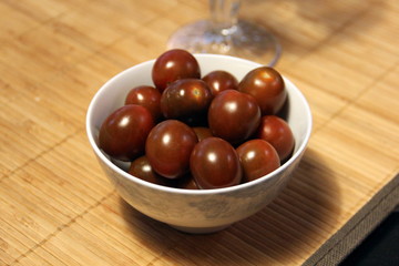 Small dark tomatoes in a white bowl