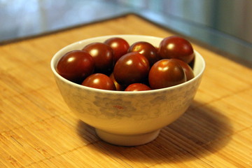 Small dark tomatoes in a white bowl