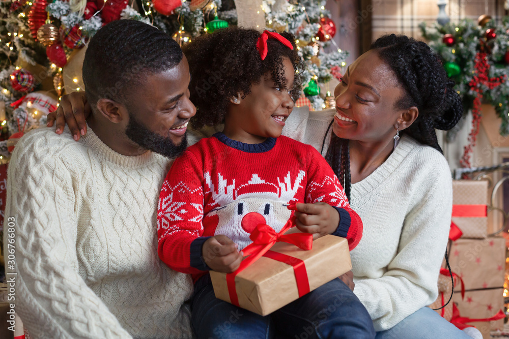 Sticker Little afro girl opening Christmas gift box with her parents