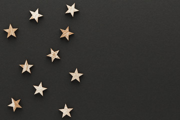 Christmas composition. Wood stars on black background top view background with copy space for your text. Flat lay.