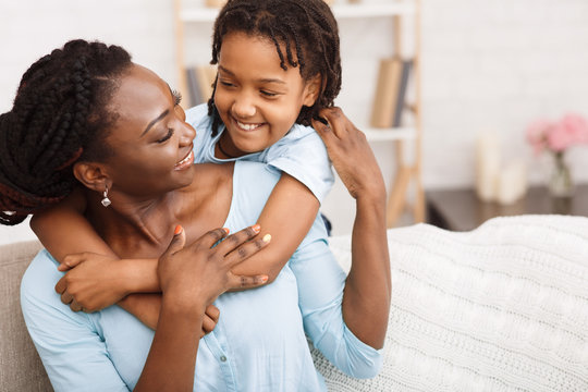 African american mother and daughter hugging at home